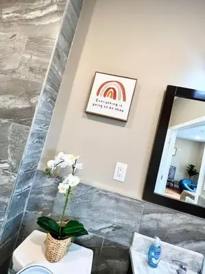 a bathroom with a mirror and a vase with flowers at 503 Bohemian Romance Apartments in center city in Philadelphia