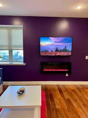 a living room with a tv on a purple wall at 504 Luxe 1BDR APT in center city in Philadelphia