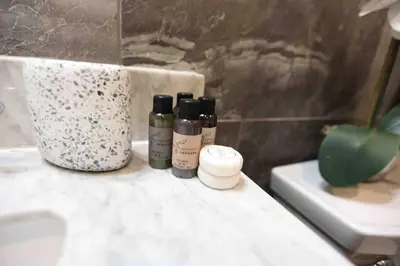 a bathroom with three bottles on a counter next to a sink at 504 Luxe 1BDR APT in center city in Philadelphia