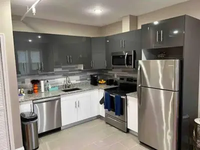 a kitchen with a stainless steel refrigerator and white cabinets at 504 Luxe 1BDR APT in center city in Philadelphia
