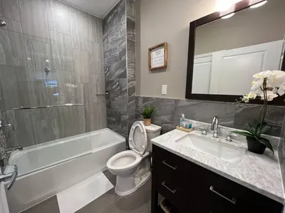 a bathroom with a tub and a toilet and a sink at 508 Urban Lifestyle king bed APT in Center CITY in Philadelphia