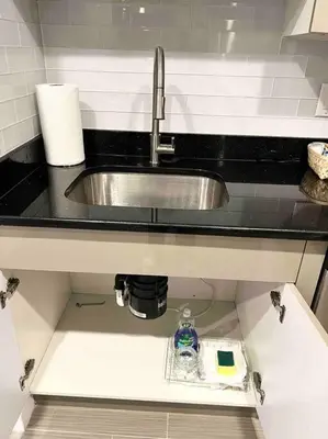 a kitchen sink with a bottle of alcohol and a soap at 402 Stylish luxe Apt at center city self check-in in Philadelphia