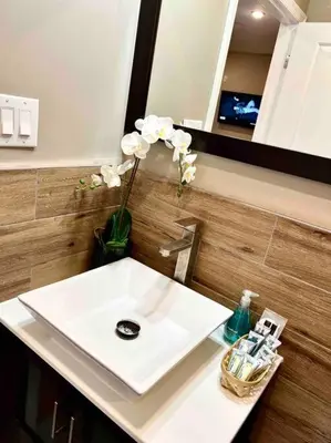 a bathroom with a white sink and a vase of flowers at 402 Stylish luxe Apt at center city self check-in in Philadelphia