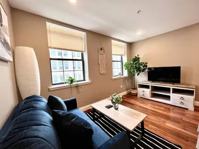 a living room with a blue couch and a table at 407 Sweetest cottage 1bed room Apt in center city in Philadelphia