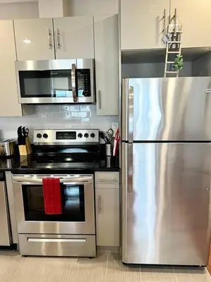 a kitchen with a stove and a stainless steel refrigerator at 407 Sweetest cottage 1bed room Apt in center city in Philadelphia