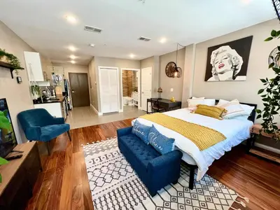 a bedroom with a large bed and a blue chair at 408 Modern styles apartment in center city of Philly in Philadelphia