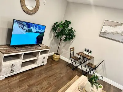a living room with a flat screen tv on a stand at 302 Comfy Cabin 1BD with city view in Center city in Philadelphia