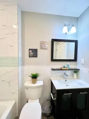 a bathroom with a toilet and a sink and a mirror at 303 Cozy and modern 1BR apartment in center City in Philadelphia