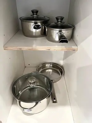 two pots and pans sitting on shelves in a kitchen at 303 Cozy and modern 1BR apartment in center City in Philadelphia