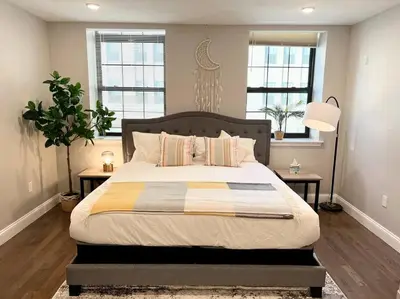 a bedroom with a large bed with two windows at 308 Cozy and warm King Bed APT in center city in Philadelphia
