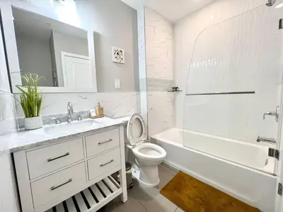 a white bathroom with a toilet and a tub and a sink at 307 Kyoto style 1BDR Apt in center city in Philadelphia