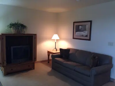 a living room with a couch and a television at All Suites Inn Budget Host in Lewisburg