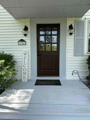 a house with a brown door and a porch at Unique Stay! Ricketts Chic Farmhouse Retreat with Stargazing Bubble Tent in Stillwater