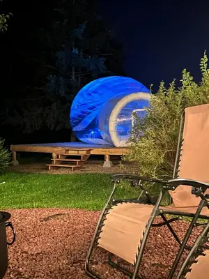 a chair and a picnic table and a blue tent at Unique Stay! Ricketts Chic Farmhouse Retreat with Stargazing Bubble Tent in Stillwater