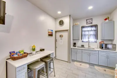 a kitchen with white cabinets and a counter and stools at Less Than 2 Mi to Downtown and Capitol Harrisburg Hideaway in Harrisburg