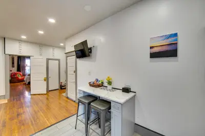 a kitchen and living room with a counter and stools at Less Than 2 Mi to Downtown and Capitol Harrisburg Hideaway in Harrisburg