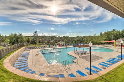 a pool at a resort with blue chairs at A Time to Remember Home in Tobyhanna with Pool! in Tobyhanna