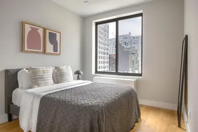 a bedroom with a bed and a large window at East Village 2br w doorman wd nr Union Square NYC-1185 in New York