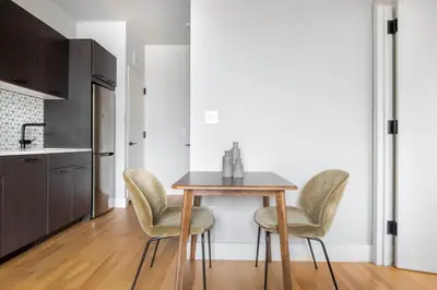 a kitchen with a table and chairs in a room at East Village 2br w doorman wd nr Union Square NYC-1185 in New York