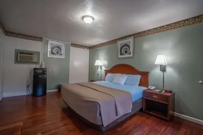 a bedroom with a large bed and a wooden floor at Mahoning Inn in Lehighton