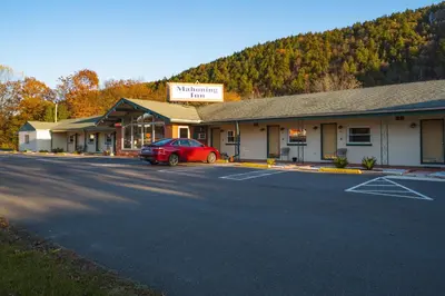 a building with a car parked in a parking lot at Mahoning Inn in Lehighton