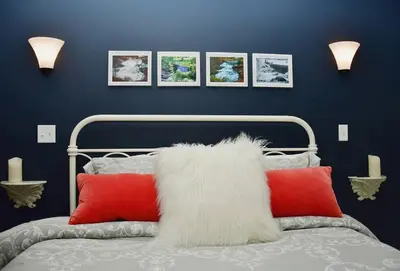 a bedroom with a bed with red and white pillows at Luxury Cottage at Millpond Falls in Warwick