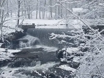 a waterfall in a forest with snow on the ground at Luxury Cottage at Millpond Falls in Warwick