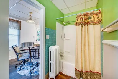 a bathroom with a tub and a chair and a table at Pool Access Bath Vacation Rental Condo! in Hollo
