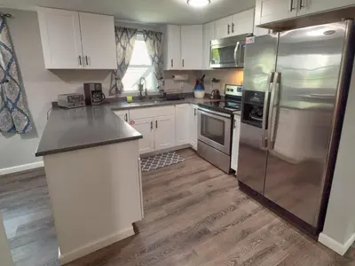 a kitchen with white cabinets and a stainless steel refrigerator at Wally's House in Hawley