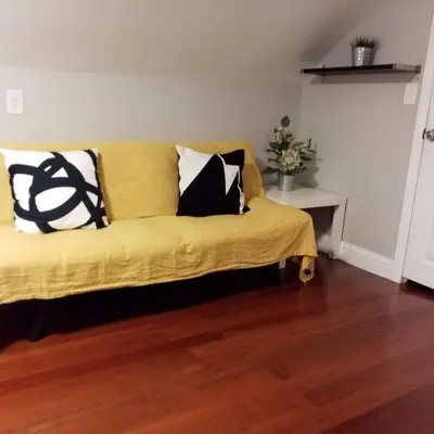 a yellow couch with pillows on it in a room at Fairmount House Free Street Parking Quiet Spacious in Philadelphia