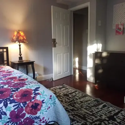a bedroom with a bed with a floral bedspread and a lamp at Fairmount House Free Street Parking Quiet Spacious in Philadelphia