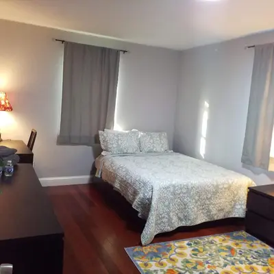 a bedroom with a bed and two windows and a rug at Fairmount House Free Street Parking Quiet Spacious in Philadelphia