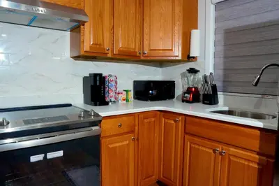 a kitchen with wooden cabinets and a stove and a sink at Serene Escape Leave Worries Behind in Wilkes-Barre