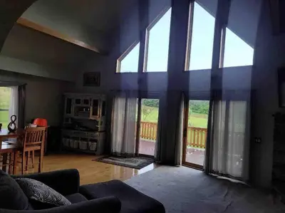 a living room with large windows and a table and chairs at Upstate getaway. Leave your troubles behind. in Unadilla