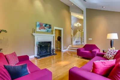 a living room with two purple couches and a fireplace at Warwick Vacation Rental with Private Yard and Fire Pit in Warwick