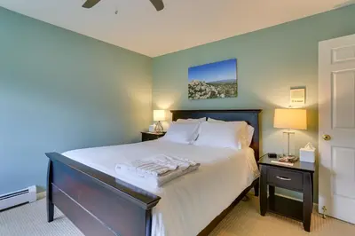 a bedroom with a large bed with white sheets at Warwick Vacation Rental with Private Yard and Fire Pit in Warwick