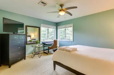 a bedroom with a bed with a ceiling fan and a desk at Warwick Vacation Rental with Private Yard and Fire Pit in Warwick