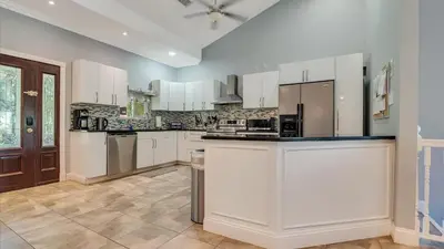 a large kitchen with white cabinets and appliances at Luxury Lake Front Camelot Villa in Pocono Lake