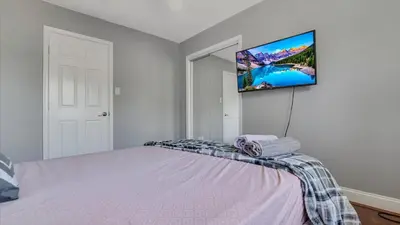 a bedroom with a bed with a tv on the wall at Luxury Lake Front Camelot Villa in Pocono Lake