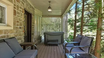 a porch with a couch and chairs and a grill at Luxury Lake Front Camelot Villa in Pocono Lake