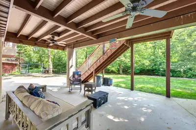 a covered patio with a couch and a staircase at Quaint Elysburg Cottage Walk to Knoebels Resort! in Paxinos