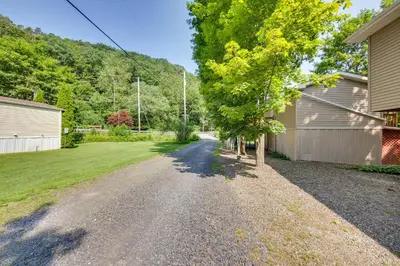 an empty driveway with a house and a tree at Quaint Elysburg Cottage Walk to Knoebels Resort! in Paxinos
