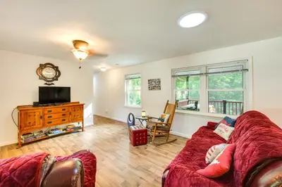 a living room with a red couch and a tv at Quaint Elysburg Cottage Walk to Knoebels Resort! in Paxinos