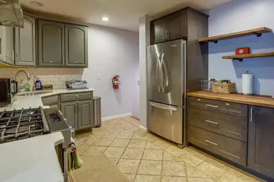 a kitchen with a stainless steel refrigerator and cabinets at Charming Monroe Township Home - 13 Mi to RU! in East Brunswick