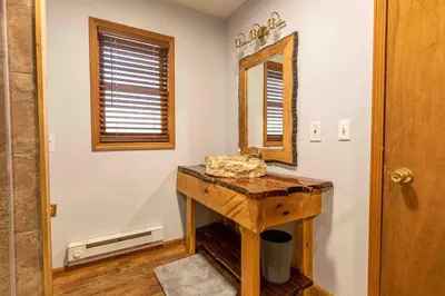 a bathroom with a wooden table and a mirror at Pocono Chalet - Hot Tub - Game Room in Albrightsville