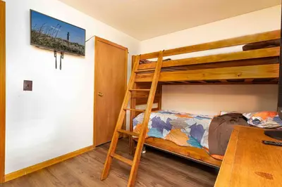 a bedroom with two bunk beds and a table at Pocono Chalet - Hot Tub - Game Room in Albrightsville