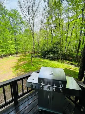 a grill sitting on top of a wooden deck at Pocono Chalet - Hot Tub - Game Room in Albrightsville