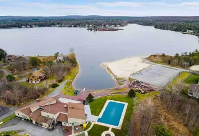 an aerial view of a house and a lake at Pocono Chalet - Hot Tub - Game Room in Albrightsville