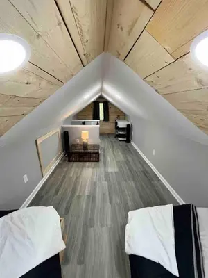 a attic room with two beds and a couch at Wally's Cottage in Hawley