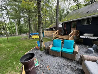 a backyard with chairs and a house with a grill at Wally's Cottage in Hawley